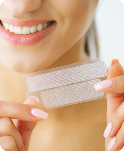 Primo piano di una  donna con in mano le  strisce sbiancati